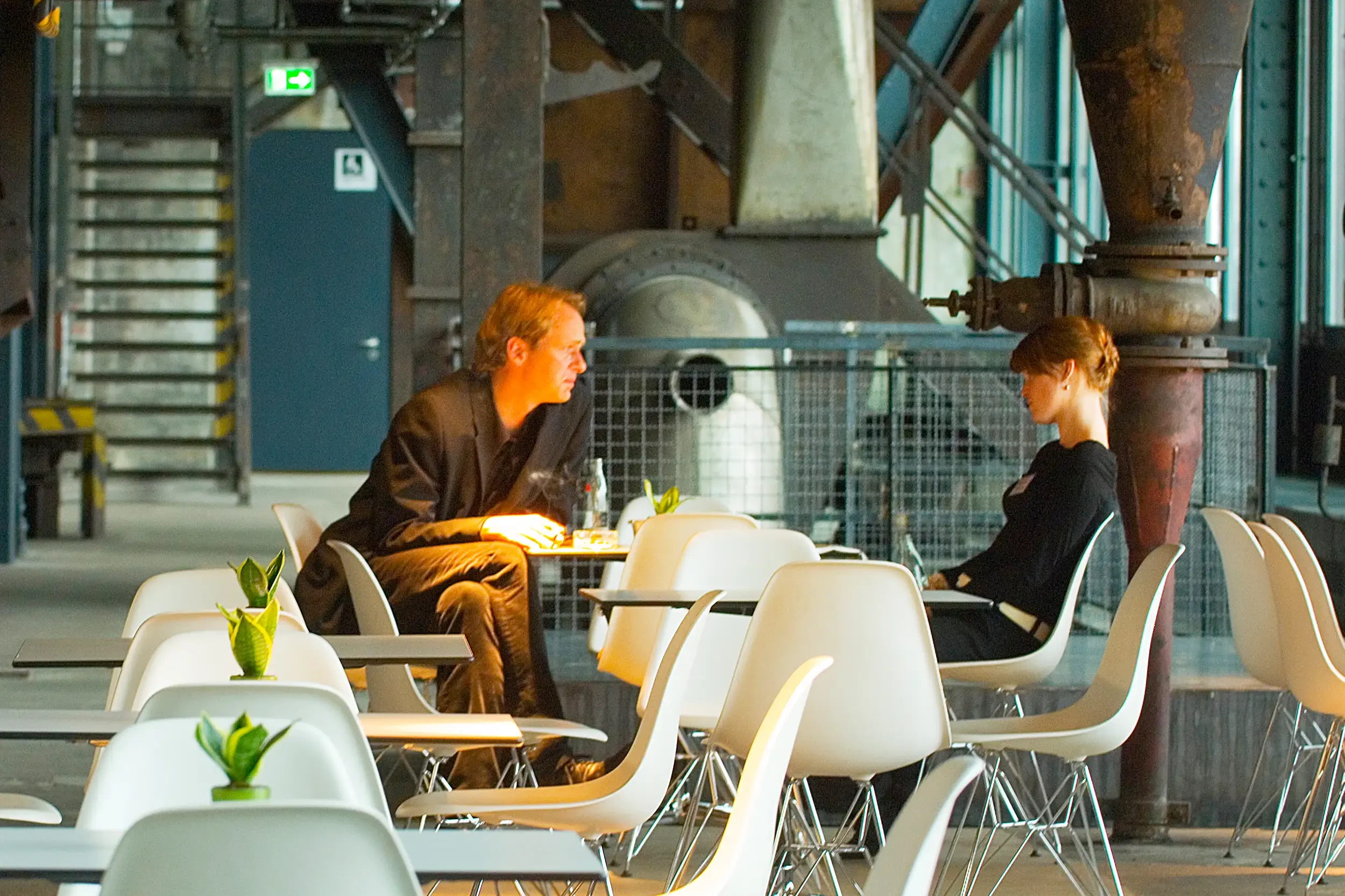 Gäste im Café Kohlenwäsche in Essen inmitten der historischen Industriekulisse
