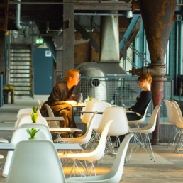 Gäste im Café Kohlenwäsche in Essen inmitten der historischen Industriekulisse