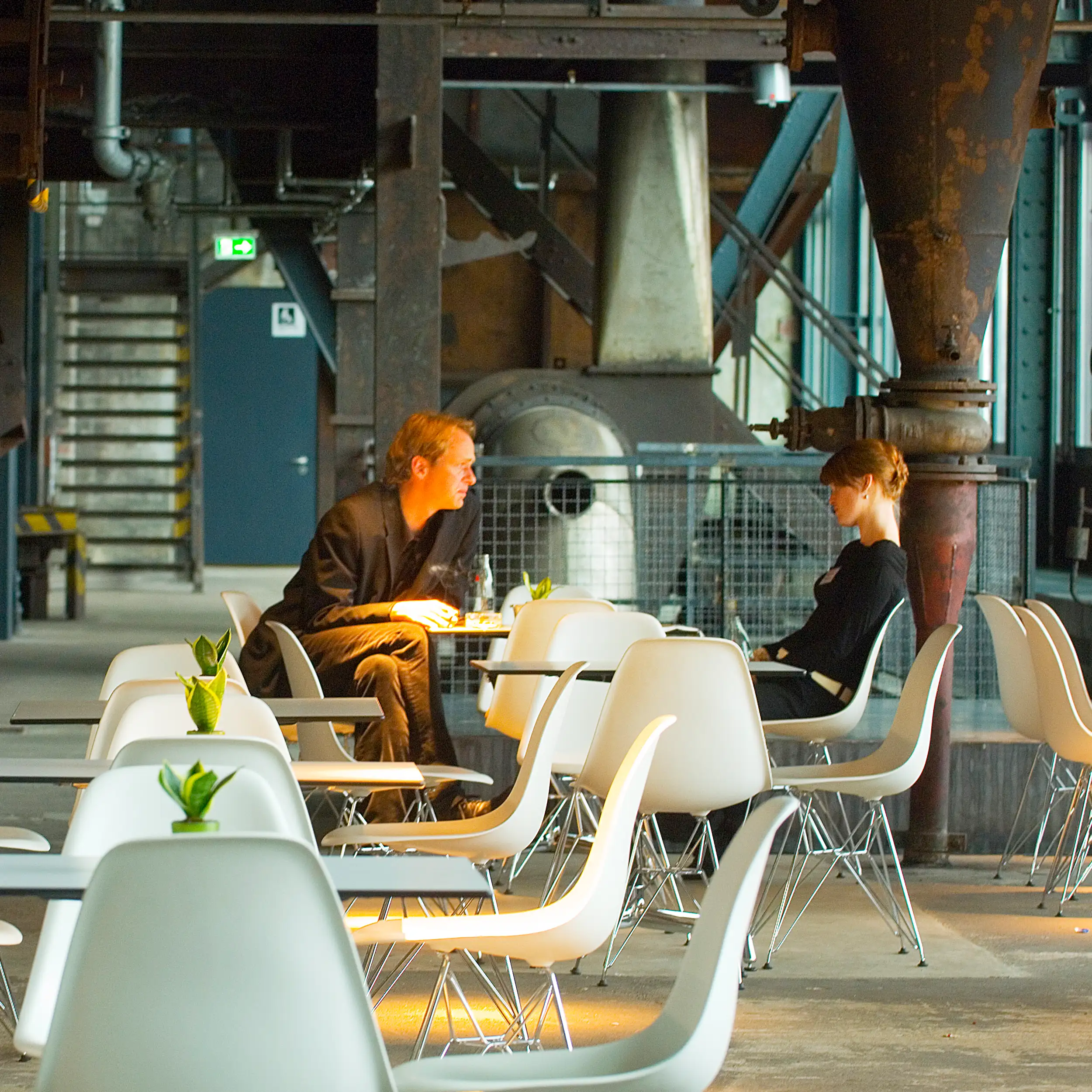 Gäste im Café Kohlenwäsche in Essen inmitten der historischen Industriekulisse