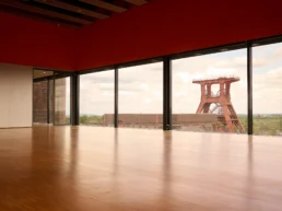 Veranstaltungsraum im Erich-Brost-Pavillon in Essen mit Panoramafenstern und Blick auf das Fördergerüst der Zeche Zollverein