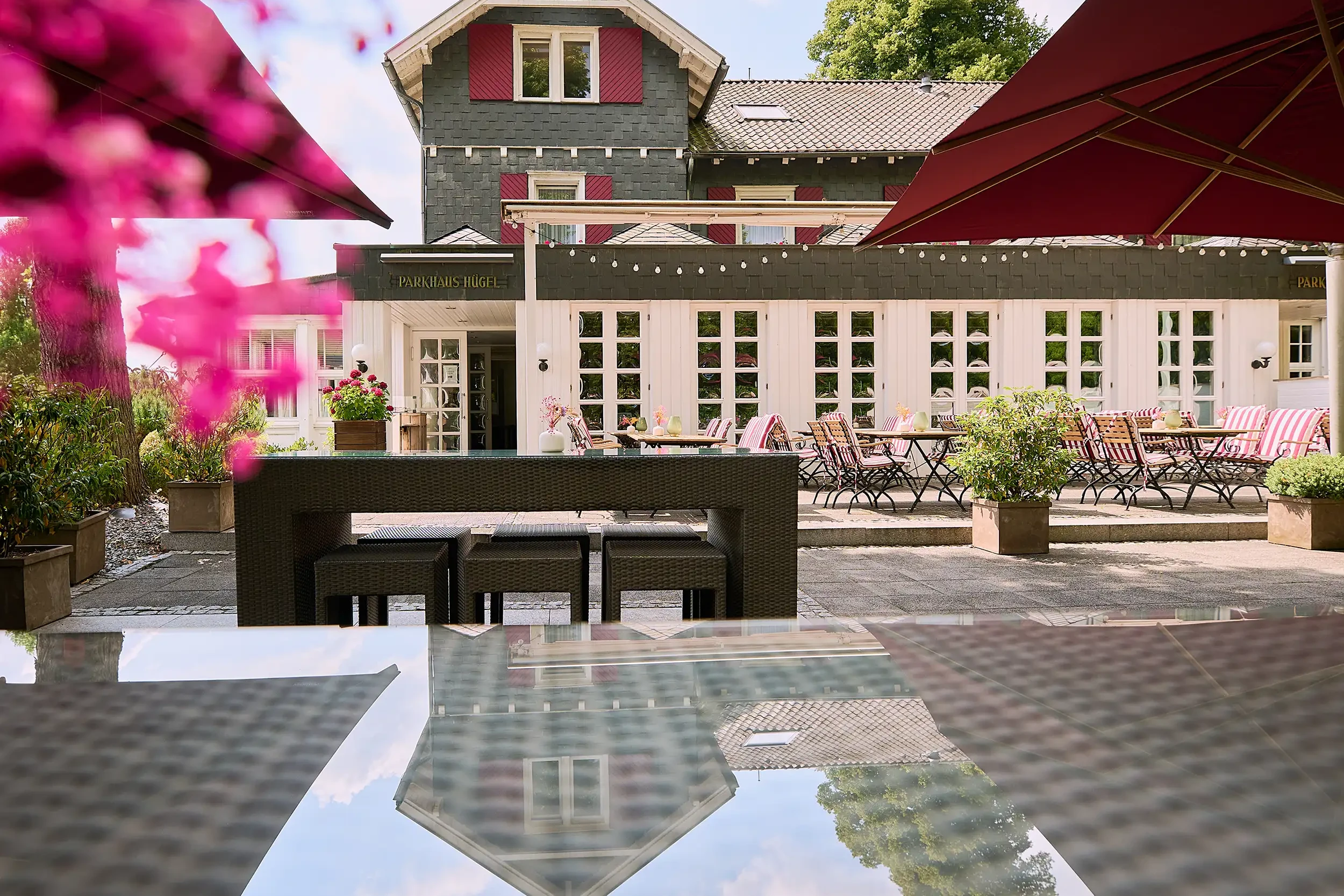 Außenansicht des Parkhaus Hügel in Essen mit Terrasse, Sitzplätzen und Sonnenschirmen