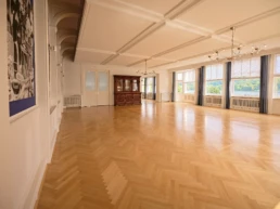 Heller Veranstaltungsraum im Parkhaus Hügel in Essen mit Parkettboden und Blick ins Grüne