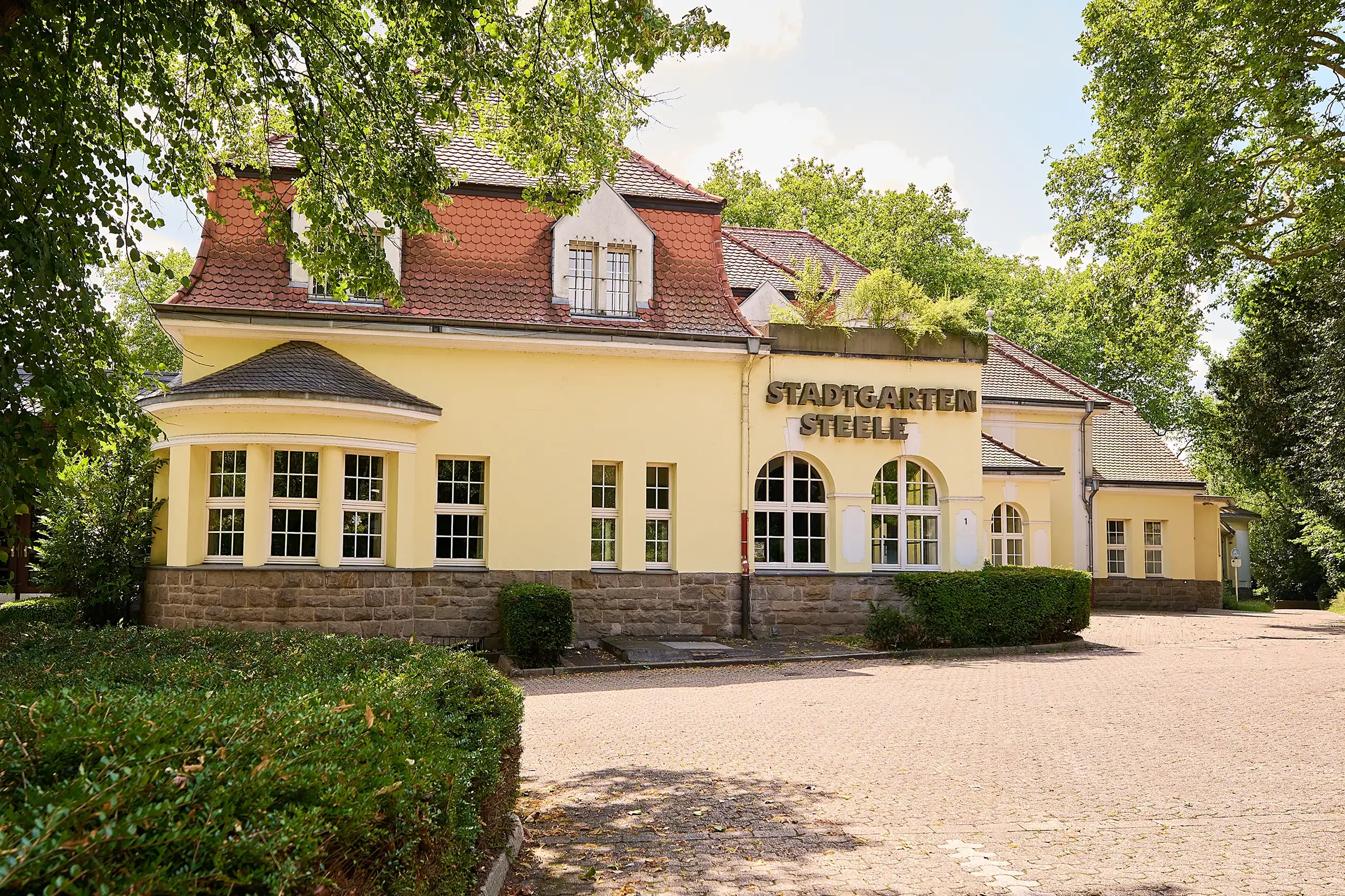 Außenansicht des Stadtgarten Steele in Essen mit historischem Gebäude und Grünanlage