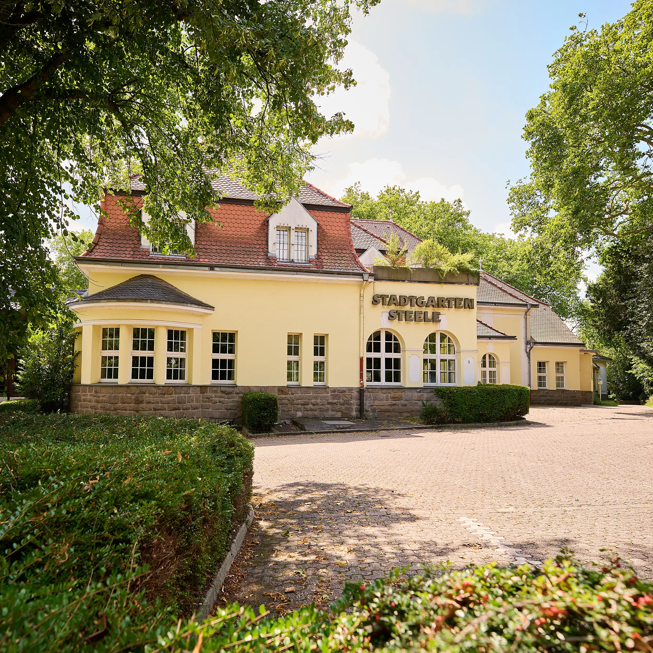 Außenansicht des Stadtgarten Steele in Essen mit historischem Gebäude und Grünanlage