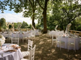 Festlich gedeckte Hochzeitstafeln im Außenbereich des Stadtgarten Steele in Essen unter altem Baumbestand