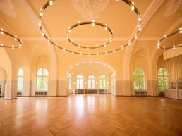 Großer Festsaal im Stadtgarten Steele in Essen mit Parkettboden, Rundbogenfenstern und moderner Ringbeleuchtung