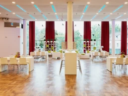 Heller Veranstaltungsraum in der Stadthalle Mülheim mit gedeckten Tischen und großen Fensterfronten