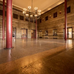 Historischer Saal im Caruso der Stadthalle M&uuml;lheim mit roten S&auml;ulen und Kronleuchter