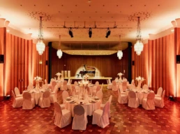 Festlich eingedeckter Veranstaltungssaal in der Stadthalle Mülheim mit Bühne und Flügel