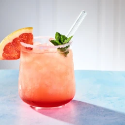 Rosafarbenes Getr&auml;nk mit Grapefruit, Minze und Eis im Glas