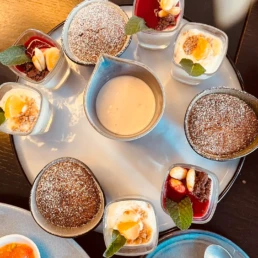 Auswahl verschiedener Desserts im Glas und kleinen Schalen