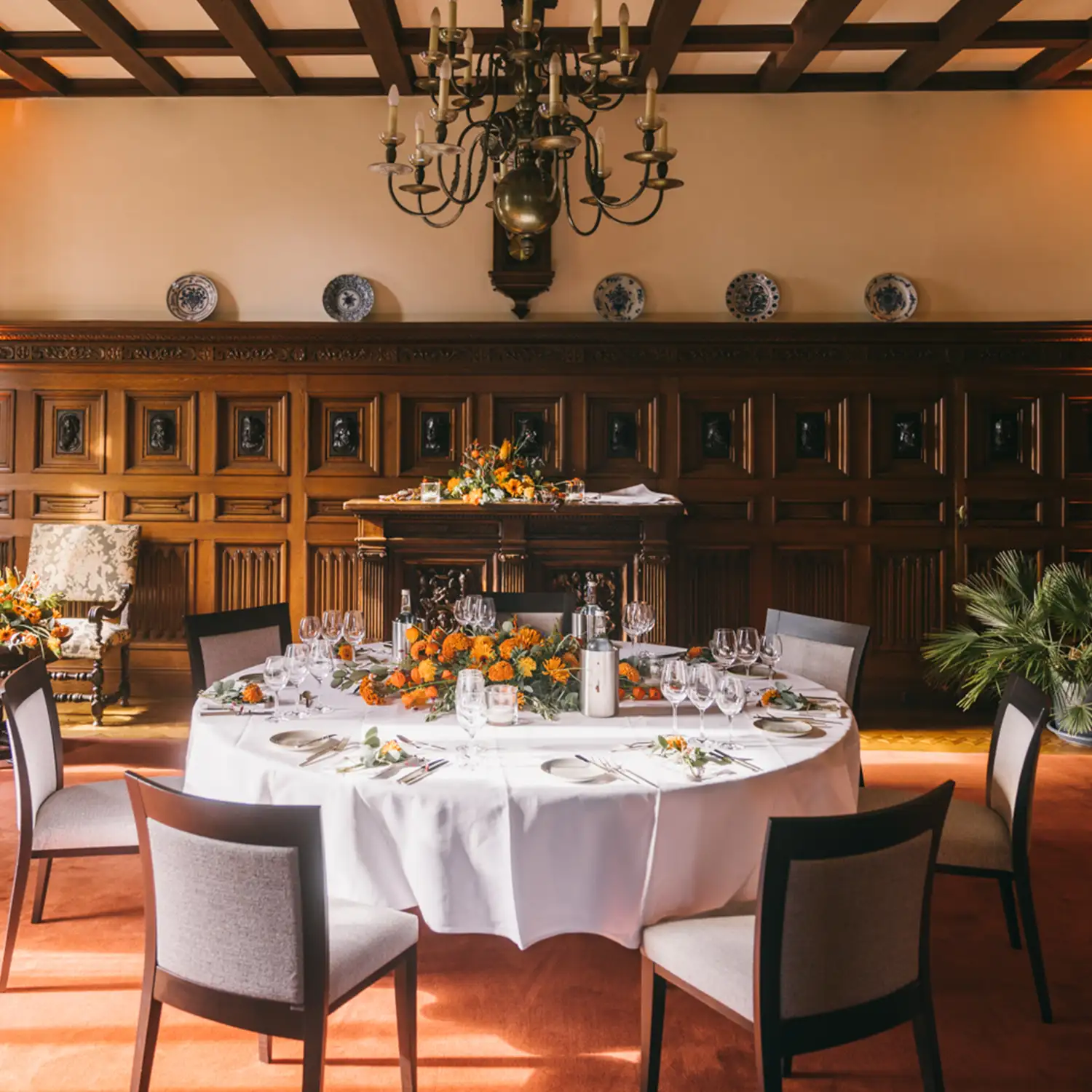 Festlich gedeckter Tisch in historischem Veranstaltungsraum mit Holzvert&auml;felung, Kronleuchter und Blumendekoration